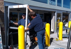 door-technicians-install-sliding-automatic-door-at-storefront